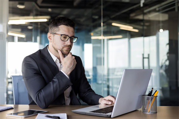 Image of a businessman looking inquisitively at his laptop