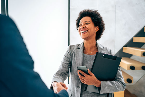Image of a smiling businesswoman shaking hands with someone