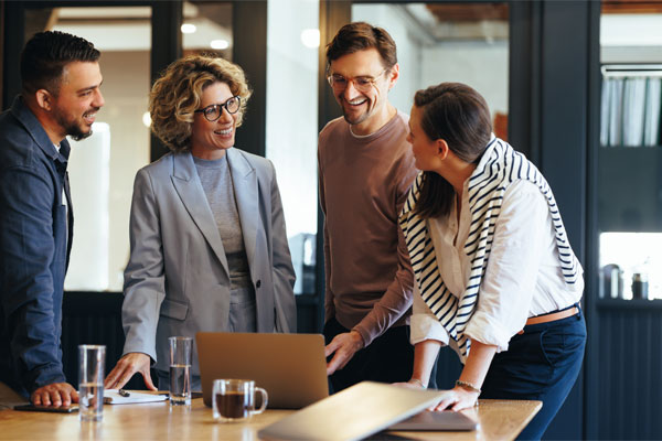 Image of a group of young professionals around a laptop