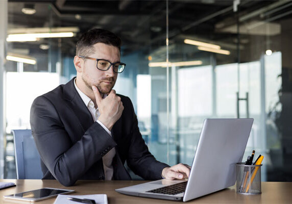 Image of a businessman looking inquisitively at his laptop