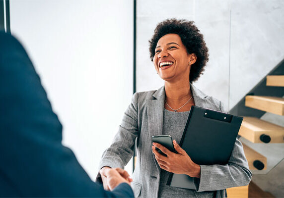 Image of a smiling businesswoman shaking hands with someone