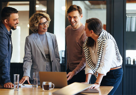 Image of a group of young professionals around a laptop