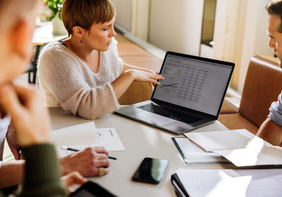 Image of a woman showing a presentation on her laptop